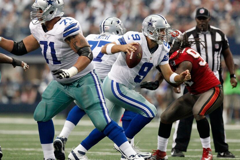 Dallas Cowboys quarterback Tony Romo (9) scrambles for yardage against the Tampa Bay...