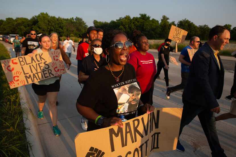 Kamona Nelson marches with other demonstrators from the Collin County Courthouse to the...