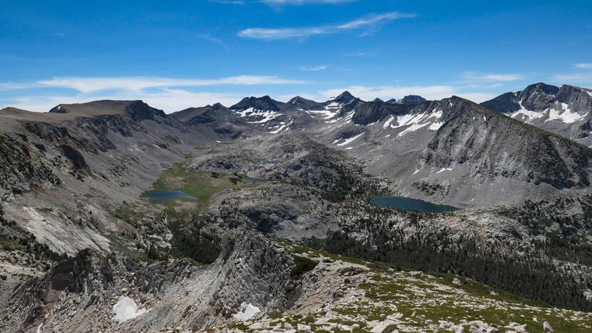 The view from atop Vogelsang Peak in Yosemite National Park is stunning, with lakes and deep...