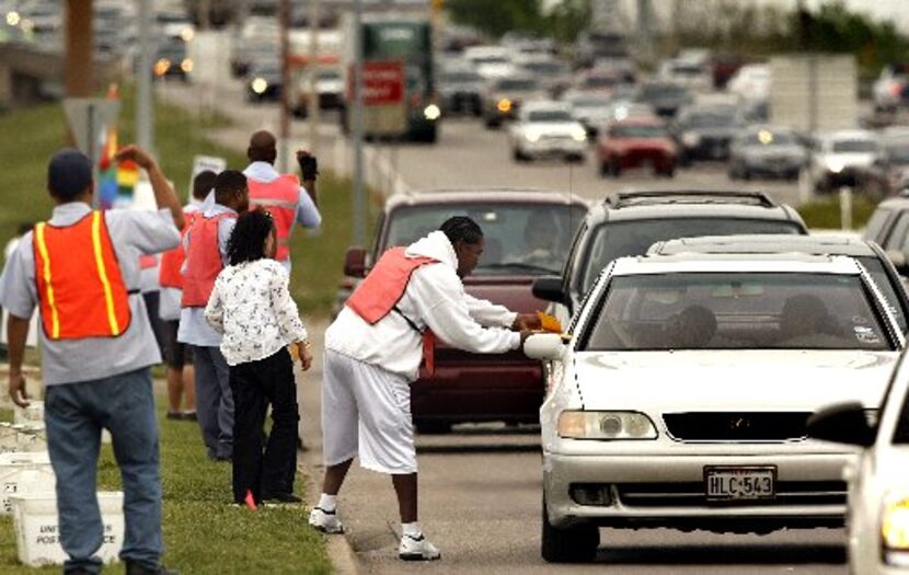 Last-day tax filers drop off their mail curbside to carrier Curtis Roy, center, outside the...