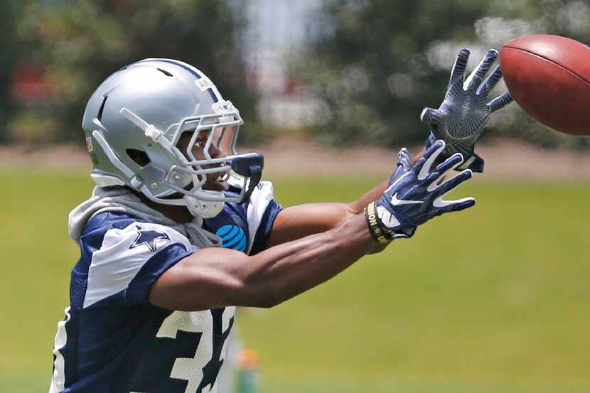 Dallas rookie cornerback Chidobe Awuzie (33) catches the ball during drills at Cowboys...
