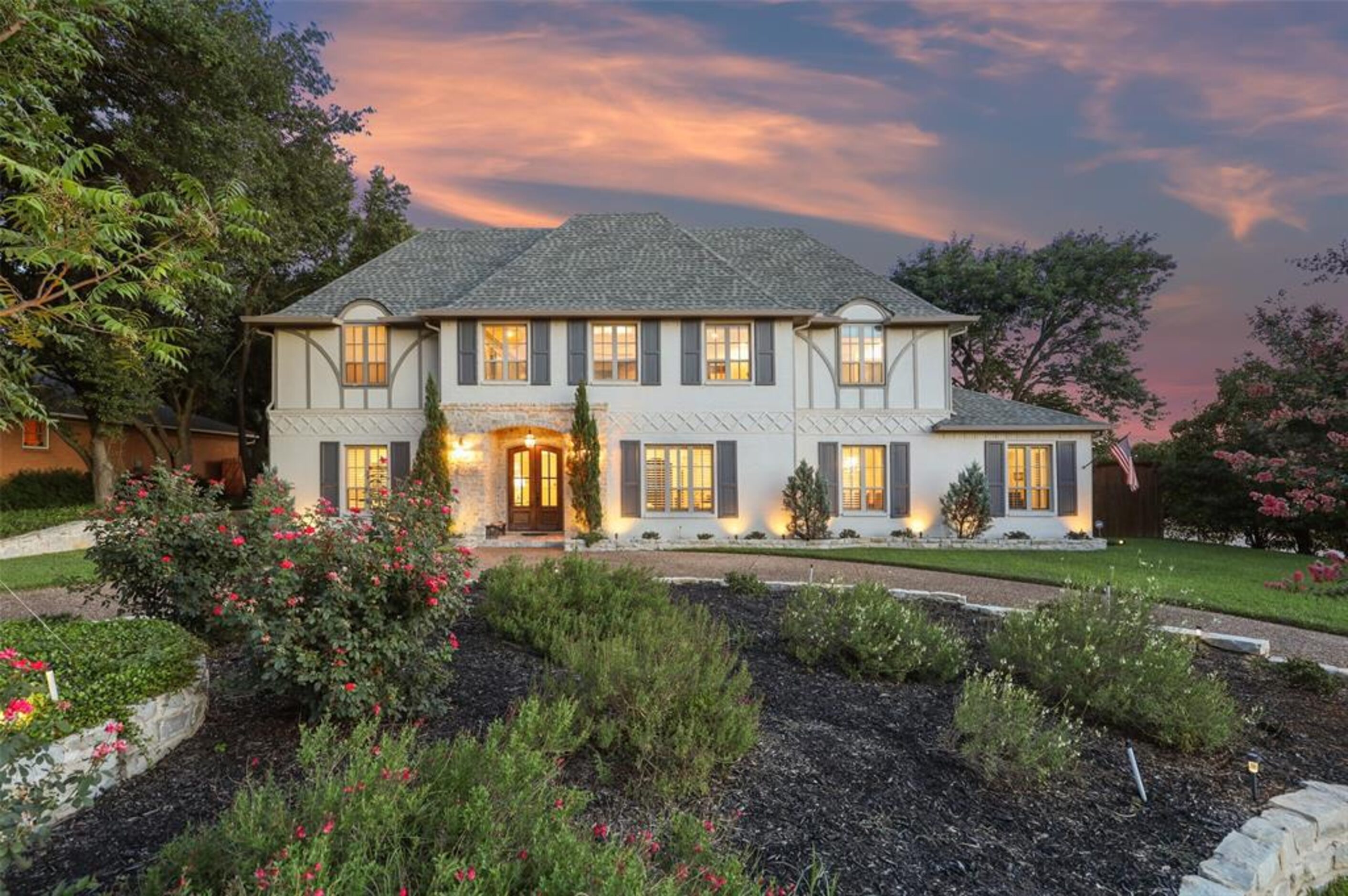 The home at 4206 Alta Vista is a large cream-colored brick home with light green shutters.