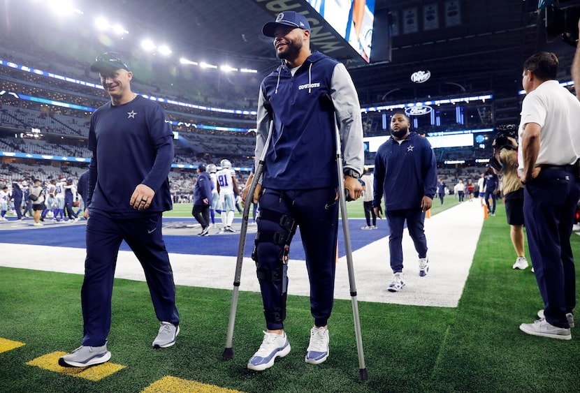 Cowboys quarterback Dak Prescott (right) walks along the sideline before Dallas' game...