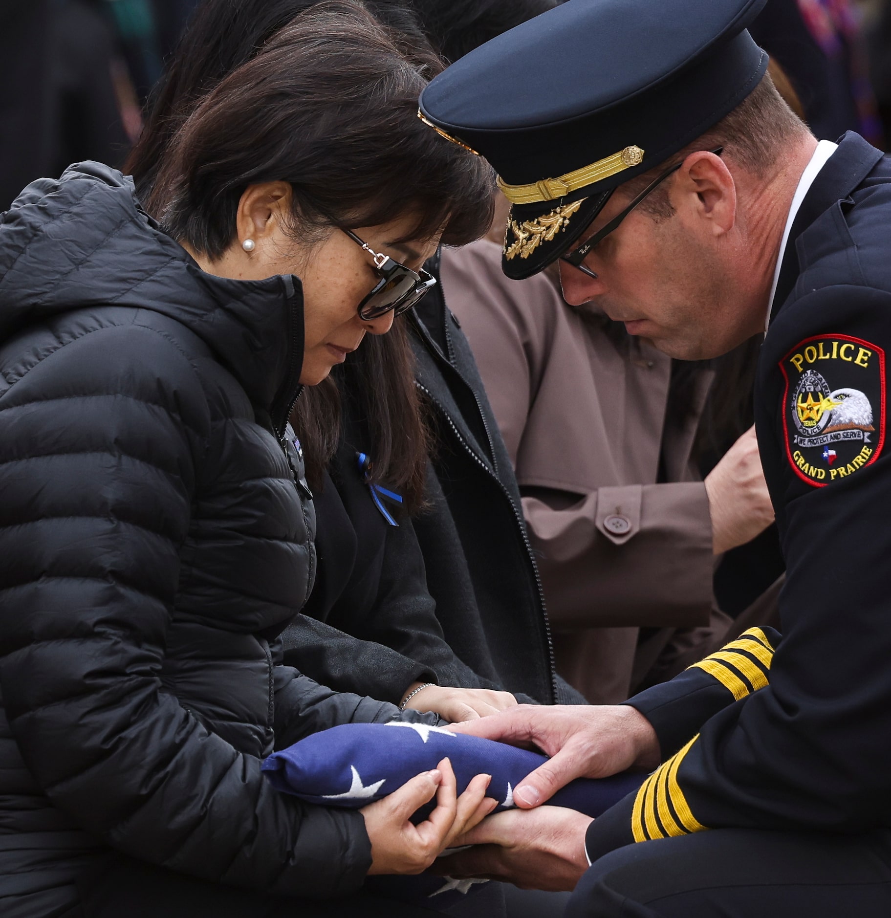 Ann Hsu, mother of  Grand Prairie police officer Brandon Tsai, is handed the American flag...