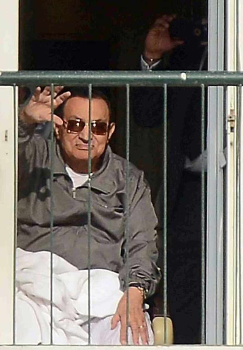 
Hosni Mubarak waved to supporters from the balcony of his room at a hospital in Cairo on...