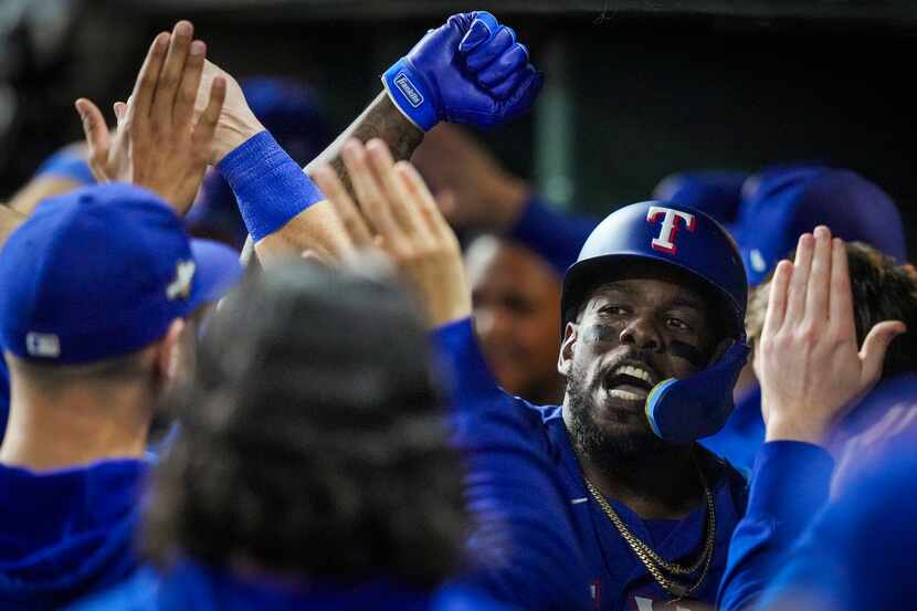 Texas Rangers right fielder Adolis Garcia celebrates with teammates after hitting a grand...