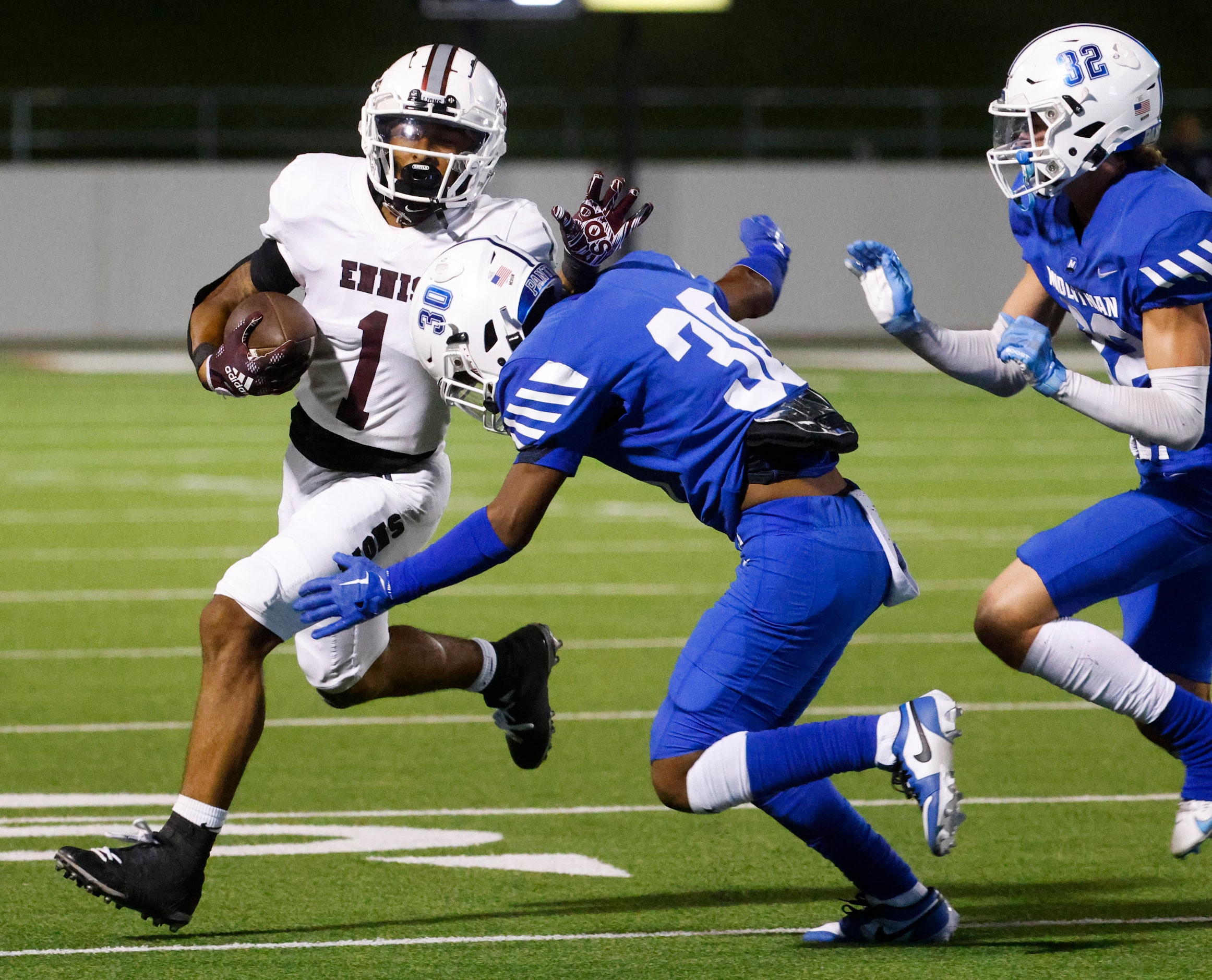 Ennis’ QB Wondame Davis Jr. (1) gets tackled by Midlothian’s Conlin Johnson (30) during the...