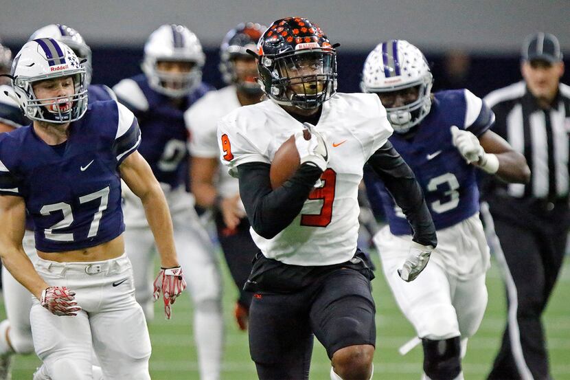 Aledo High School running back Jase McClellan (9) looks at the overhead video screen to see...
