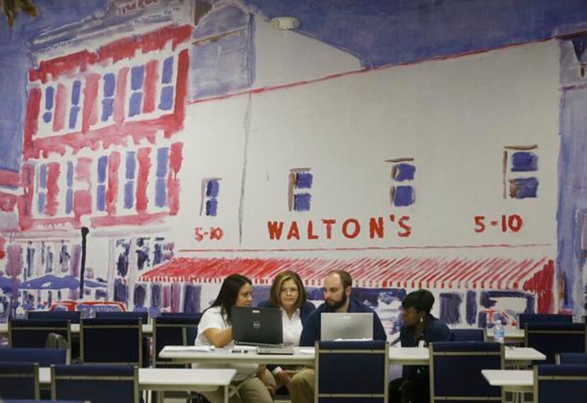 A painting depicting Wal-Mart founder Sam Walton's first five-and-time store adorns a wall...