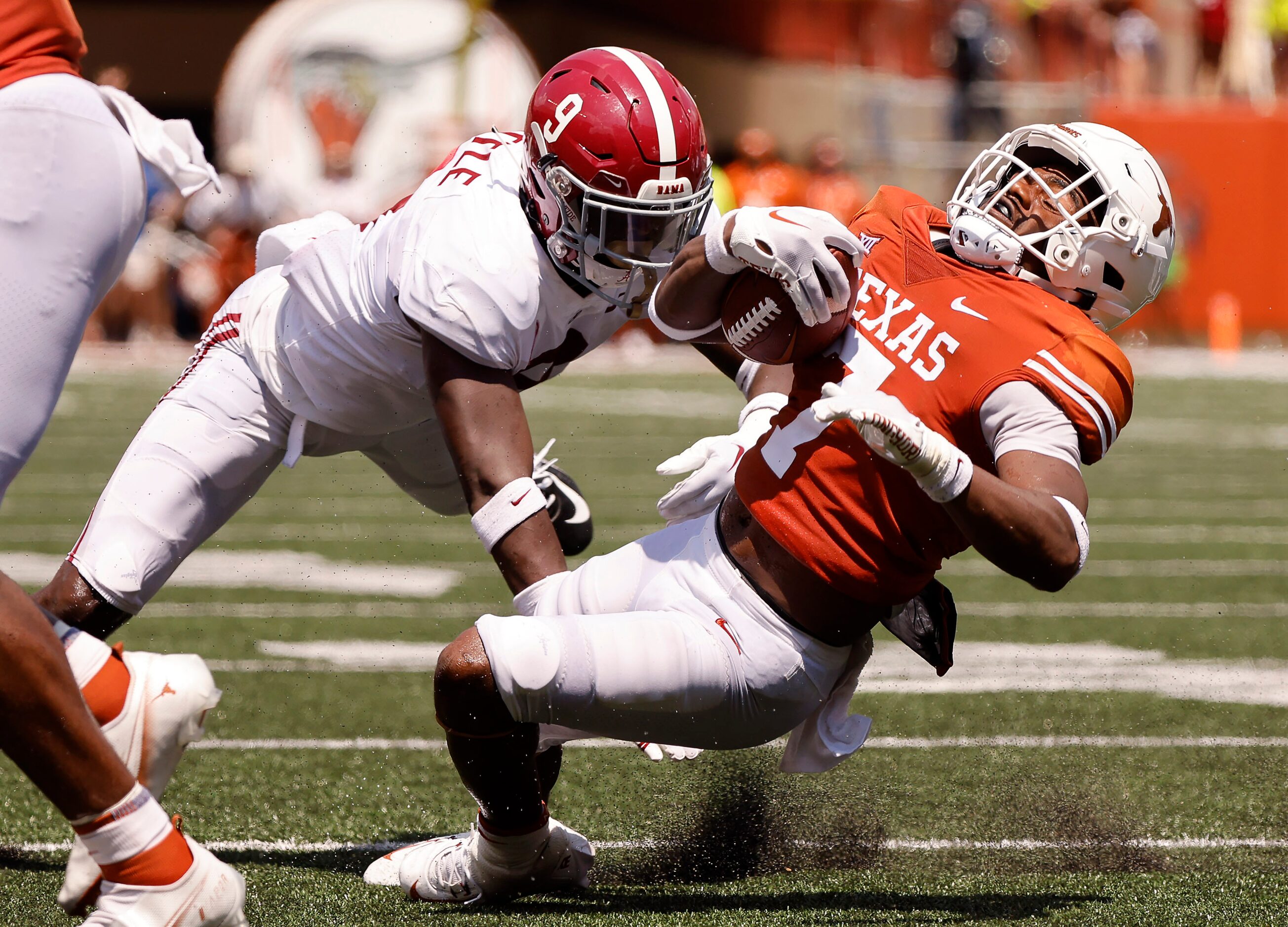 Texas Longhorns running back Keilan Robinson (7) was brought down by his face mask by...