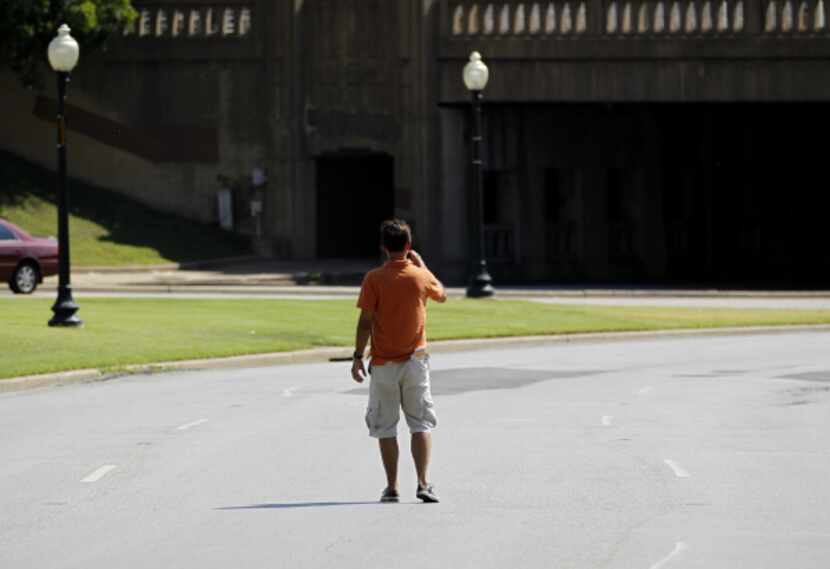 A man stood in the street near the triple underpass Wednesday to get a photo of the spot...