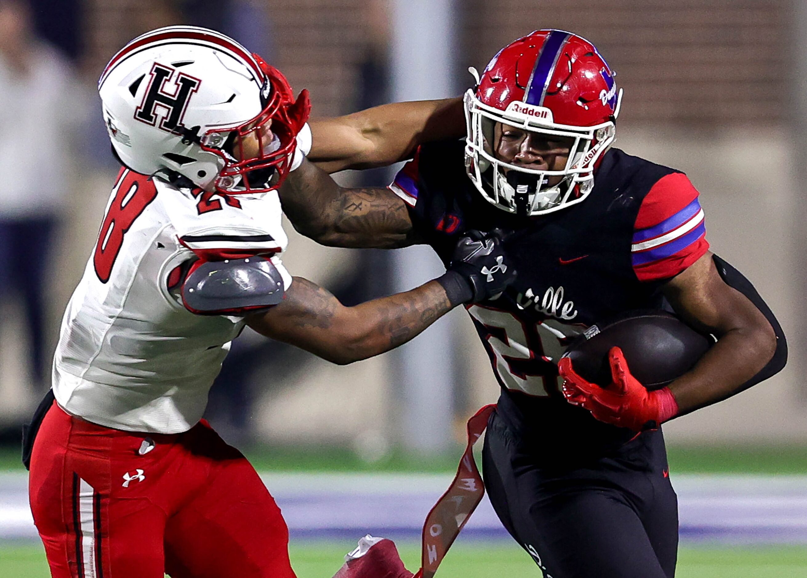 Duncanville running back Caden Durham (29) gives a stiff arm to Rockwall Heath linebacker...