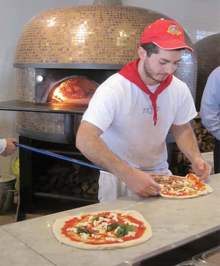 In this file photo from the Frisco restaurant, a Pizzeria Testa employee makes pies to put...