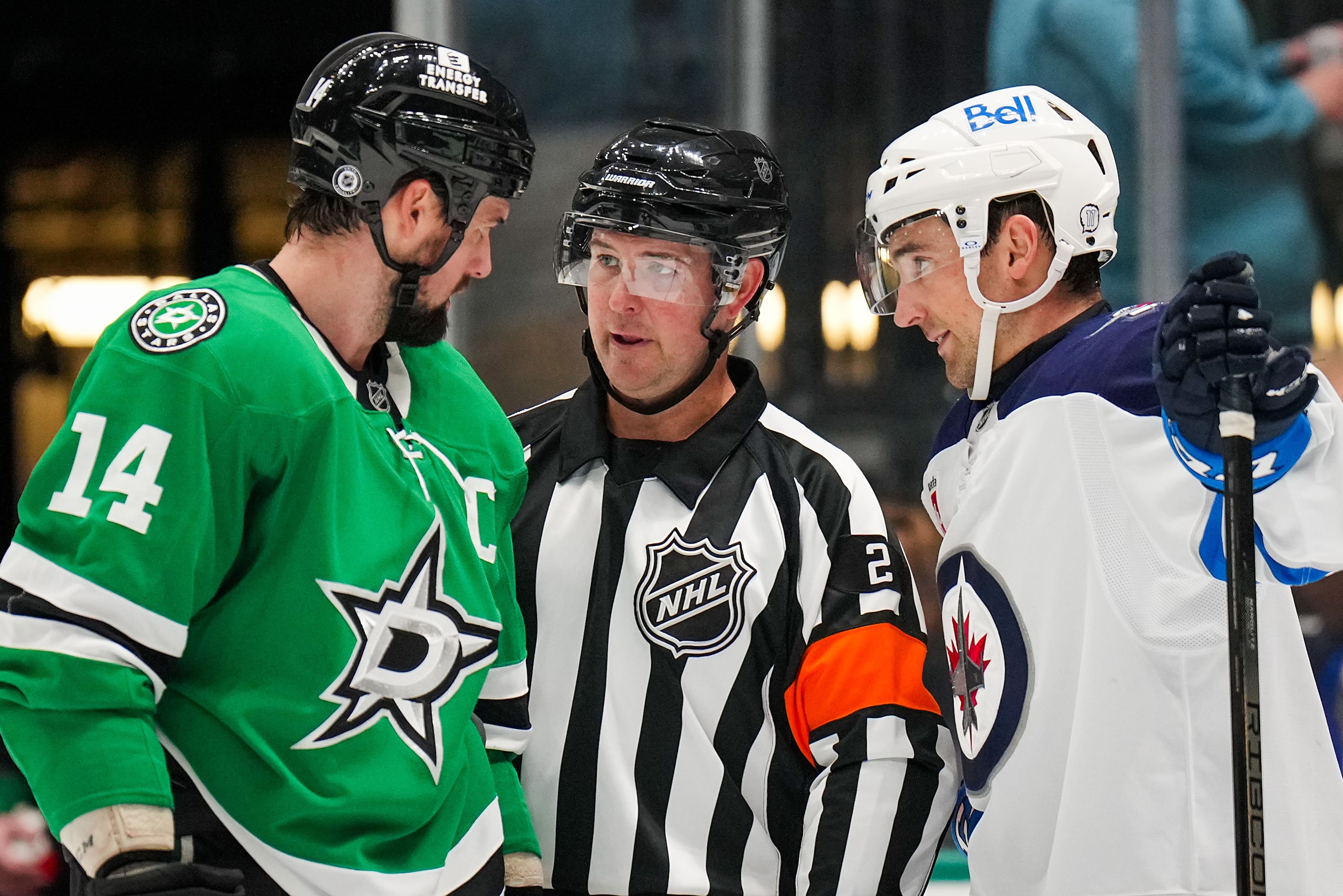 Dallas Stars left wing Jamie Benn (14) and Winnipeg Jets defenseman Neal Pionk (4) talk with...