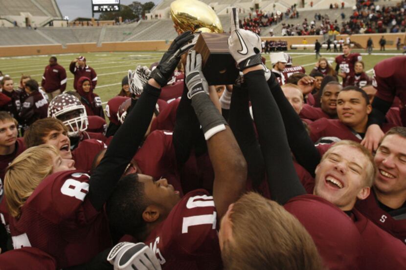 SHERMAN 28, ROCKWALL-HEATH 25: The Sherman football team celebrates with the trophy after...