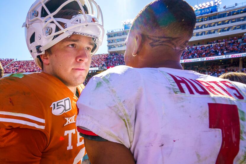 Texas quarterback Sam Ehlinger (11) hugs Oklahoma quarterback Jalen Hurts (1) after the...