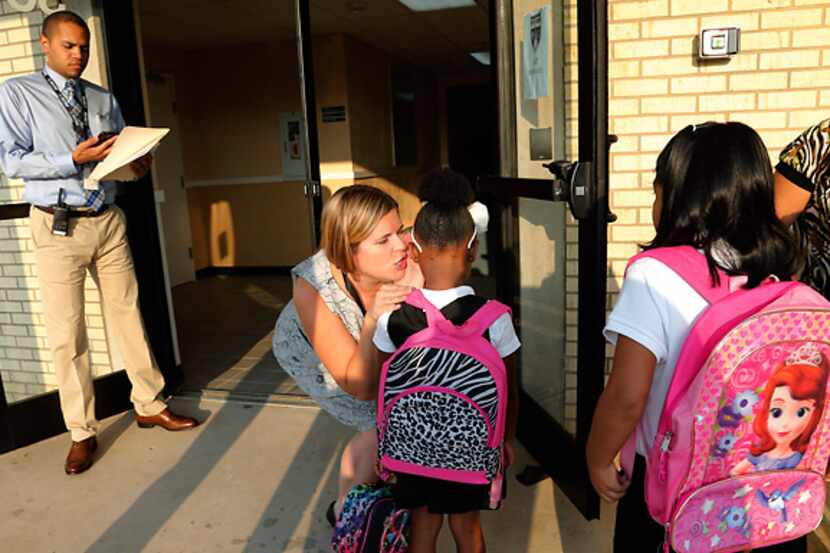 Emily Huggins of Uplift Grand Preparatory school greets students arriving for the first day...
