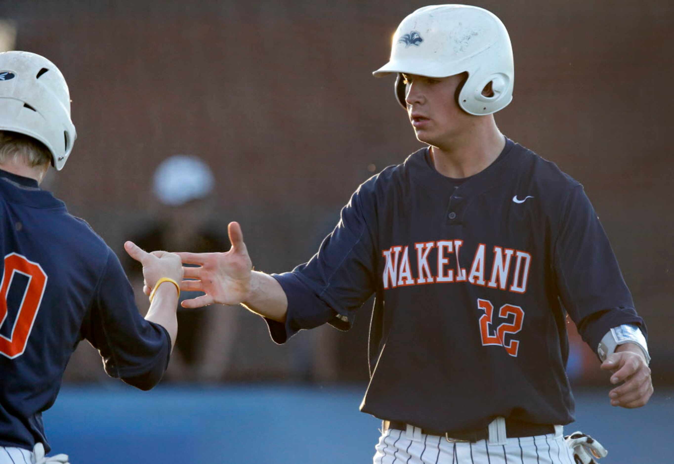 Wakeland High School first baseman Jared Martin (22) is congratulated after scoring a run in...