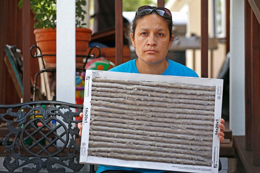 Rosa Ayala shows a caked up air filter recently swapped out at her home in McKinney's High...