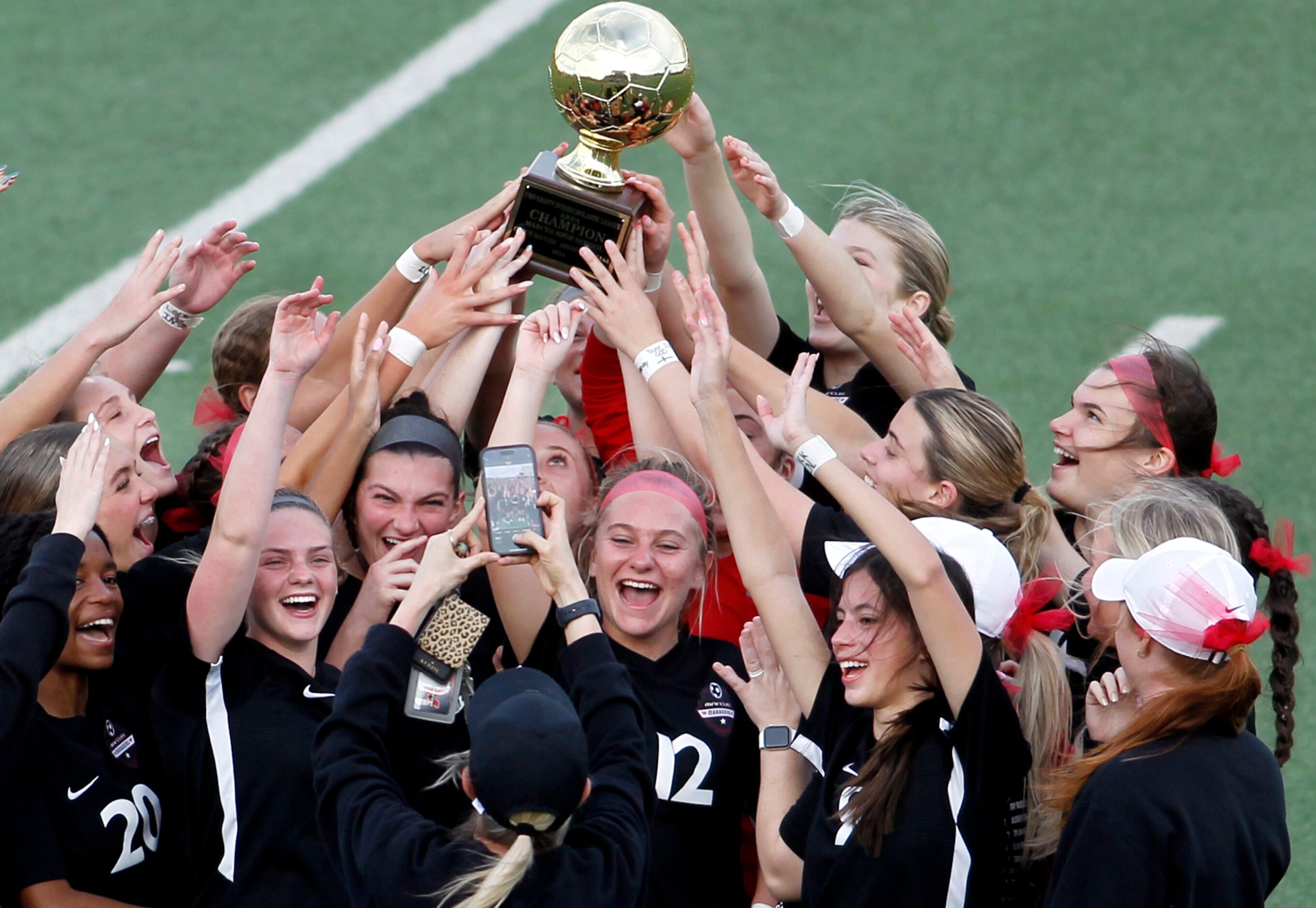 Flower Mound Marcus players revel in the moment as they pose for a photo with their Area...