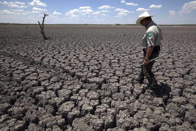  Texas State Park police officer Thomas Bigham walks across the cracked lake bed of O.C....
