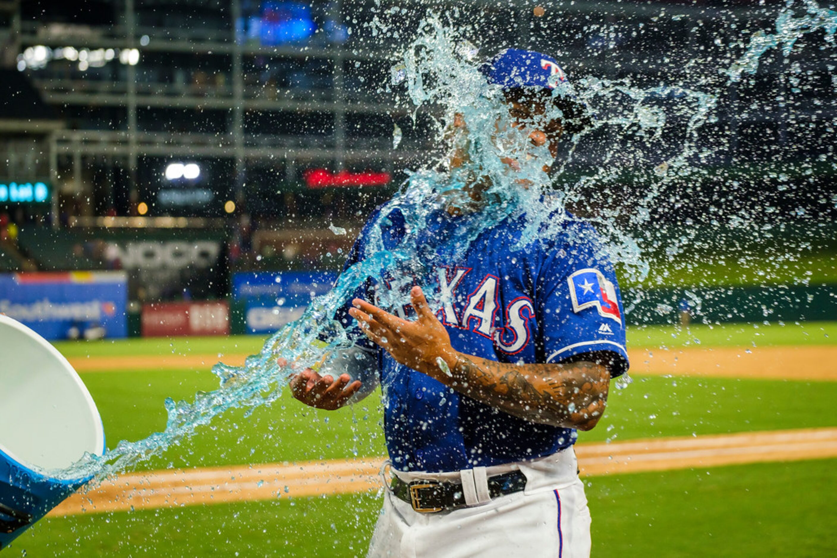 Texas Rangers left fielder Willie Calhoun is doused by second baseman Rougned Odor (12) ...