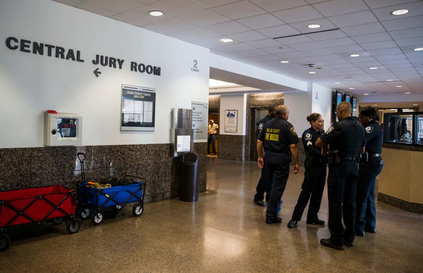 A Fire Marshall talks with security guards in the hallway outside the Central Jury Room as...