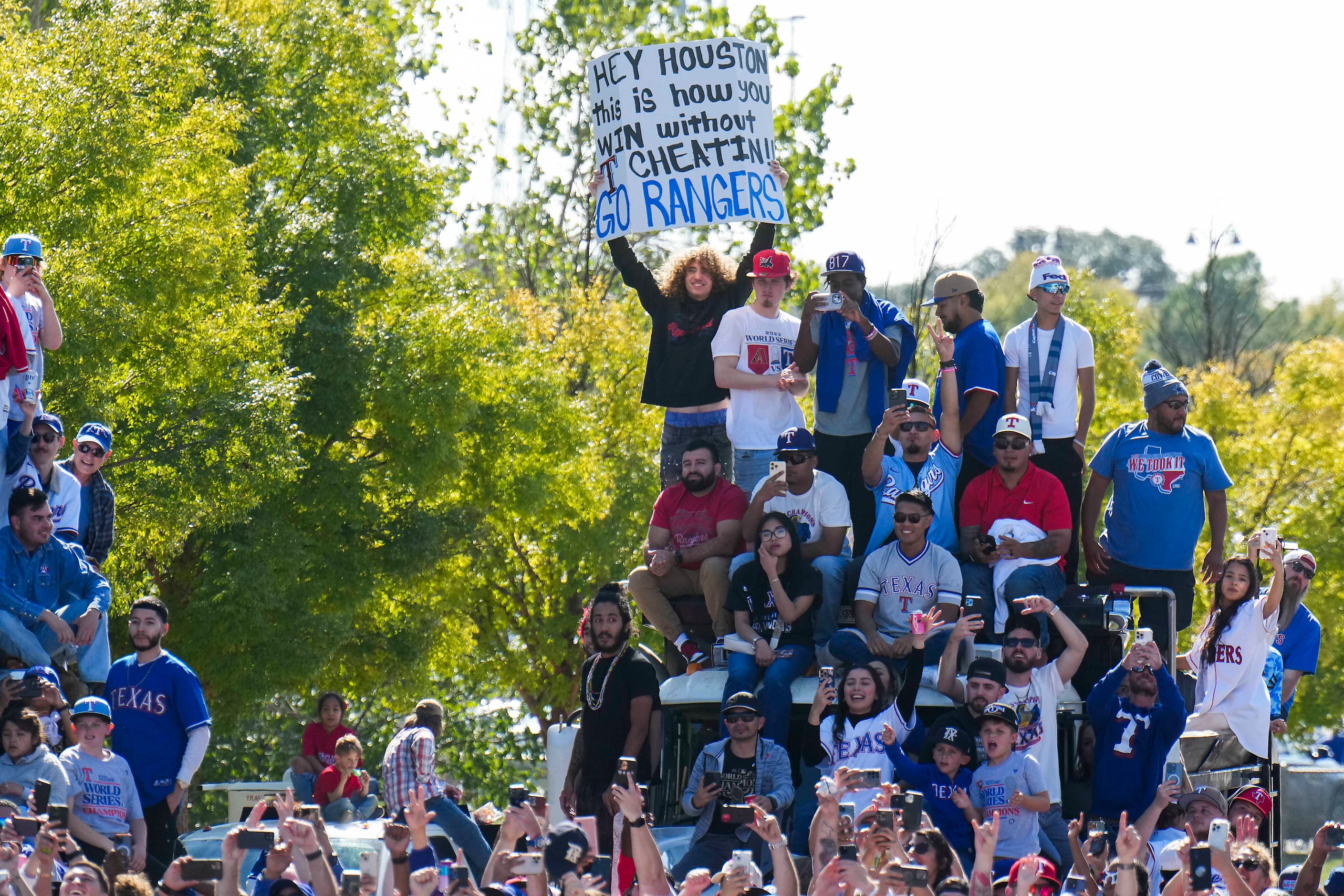 Fans perch on a truck to get a view along the parade route during the Texas Rangers World...