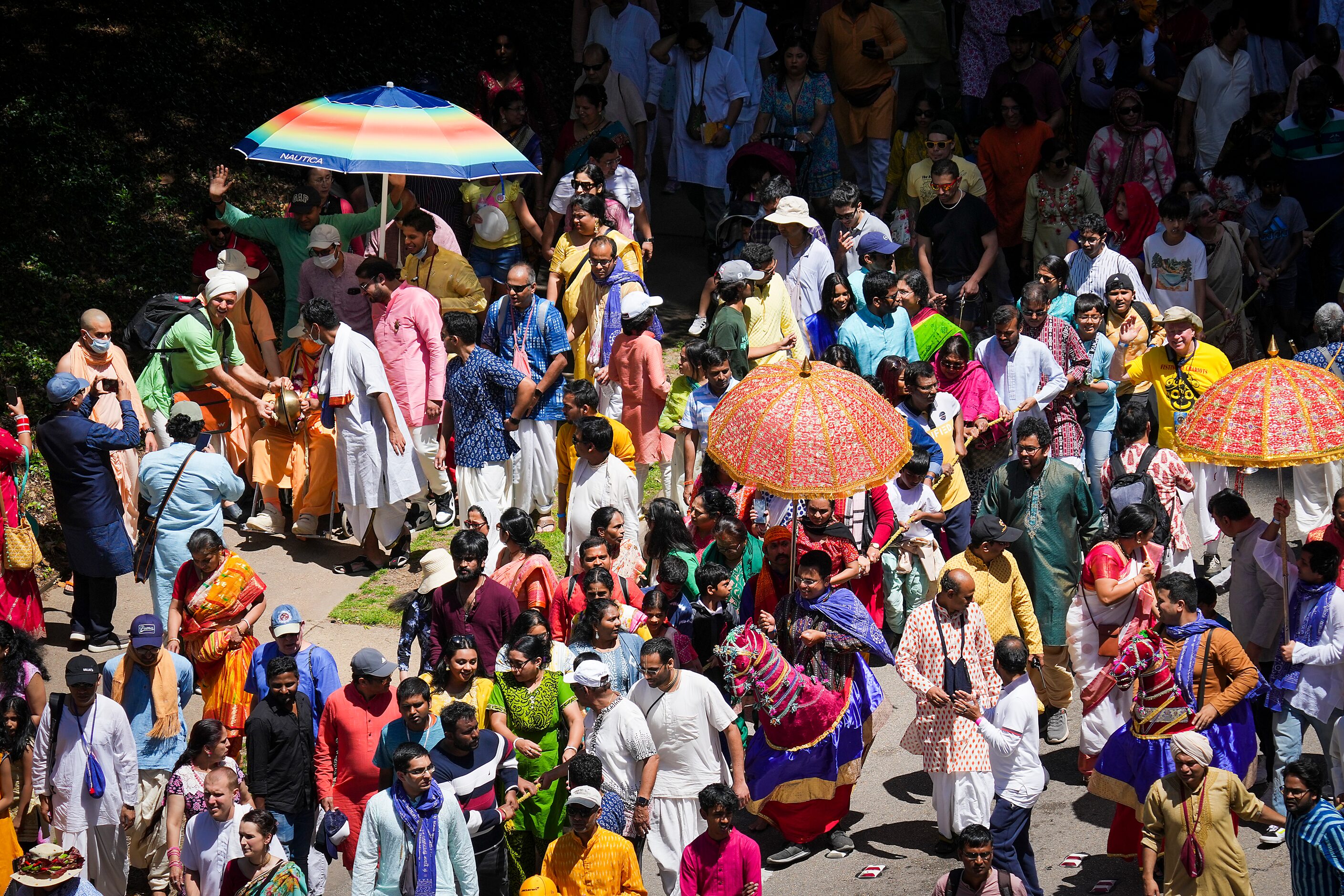 Revelers participating in the Ratha Yatra parade dance down Ross Avenue downtown during the...