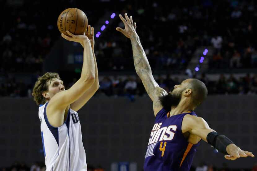 Dallas Mavericks Dirk Nowitzki tries to shoot over Phoenix Suns Tyson Chandler in the first...