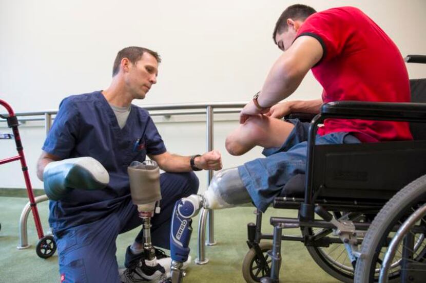 
Scott Williams checks one of Cela’s legs after he wore a prosthetics mold for the first...