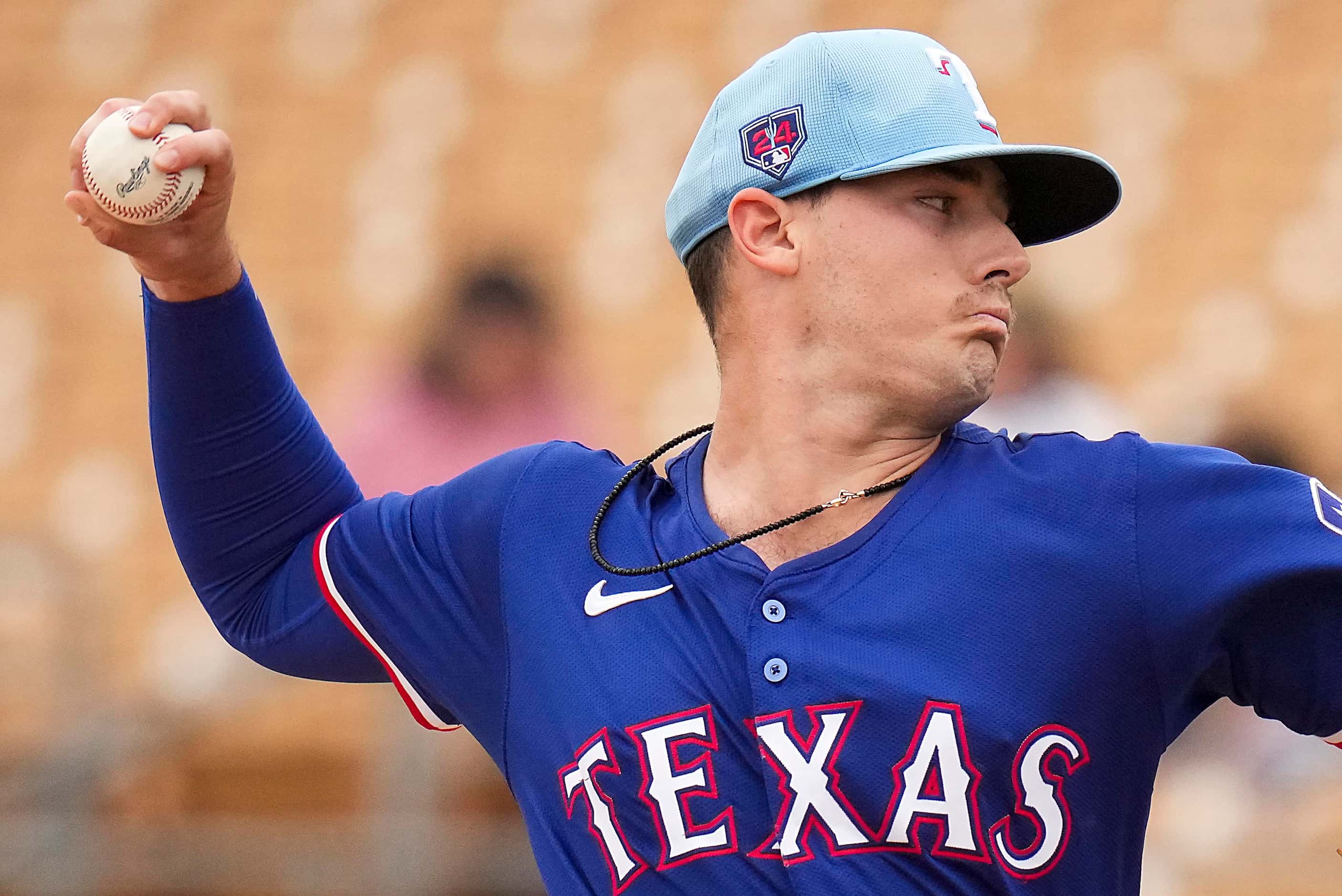 Texas Rangers pitcher Cole Winn delivers during the first inning of a spring training game...