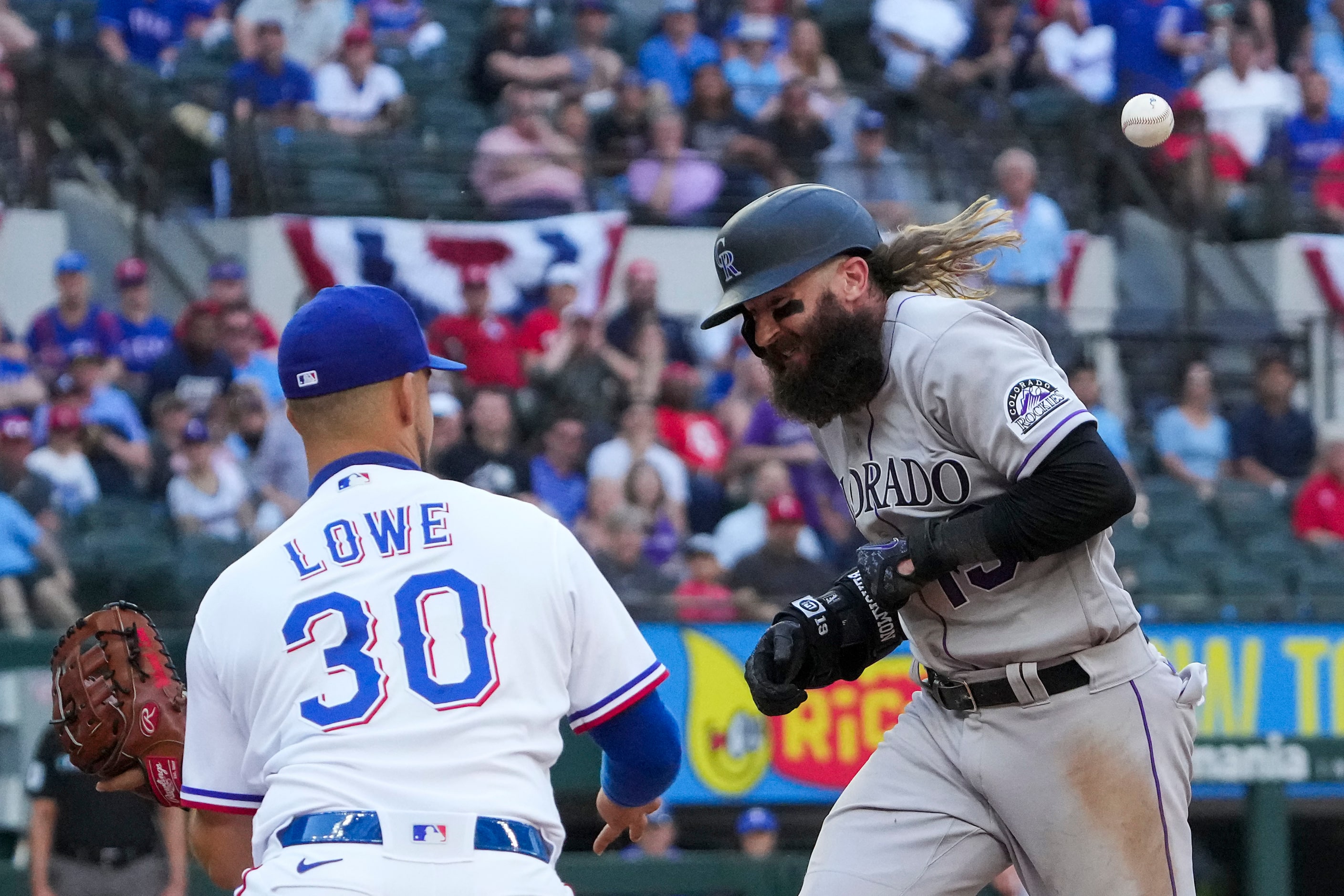 Colorado Rockies right fielder Charlie Blackmon is hit in the back as he is caught in a...