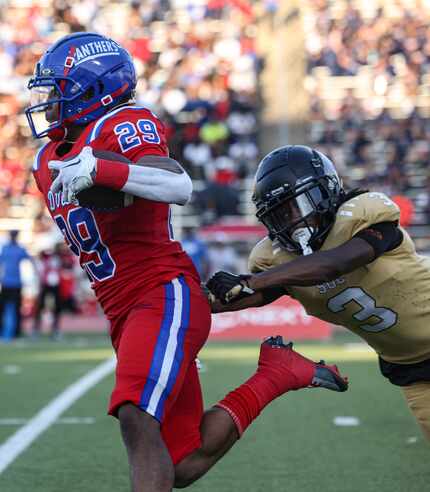 Duncanville's Caden Durham (29) avoids a tackle by South Oak Cliff's Taylor Starling (3) and...