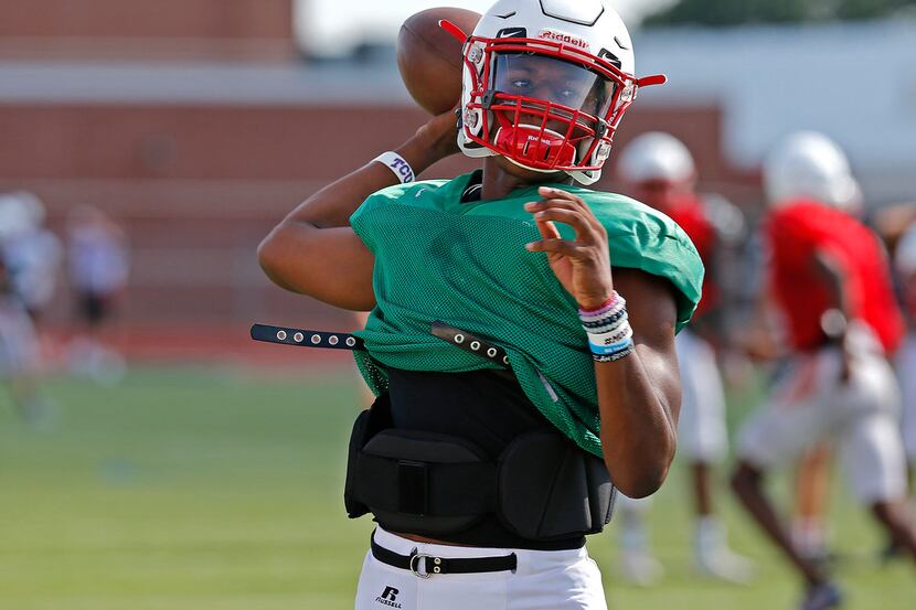 Quarterback Brendon Lewis throws a pass during football practice for Melissa High School at...