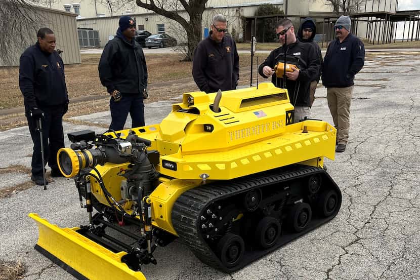 Dallas Fire-Rescue personnel observe a demonstration model of Howe and Howe Technologies'...