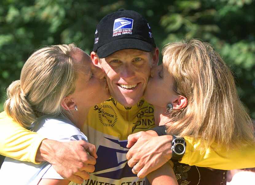 Tour de France winner Lance Armstrong is kissed by his wife Kristin, left, and his mother...