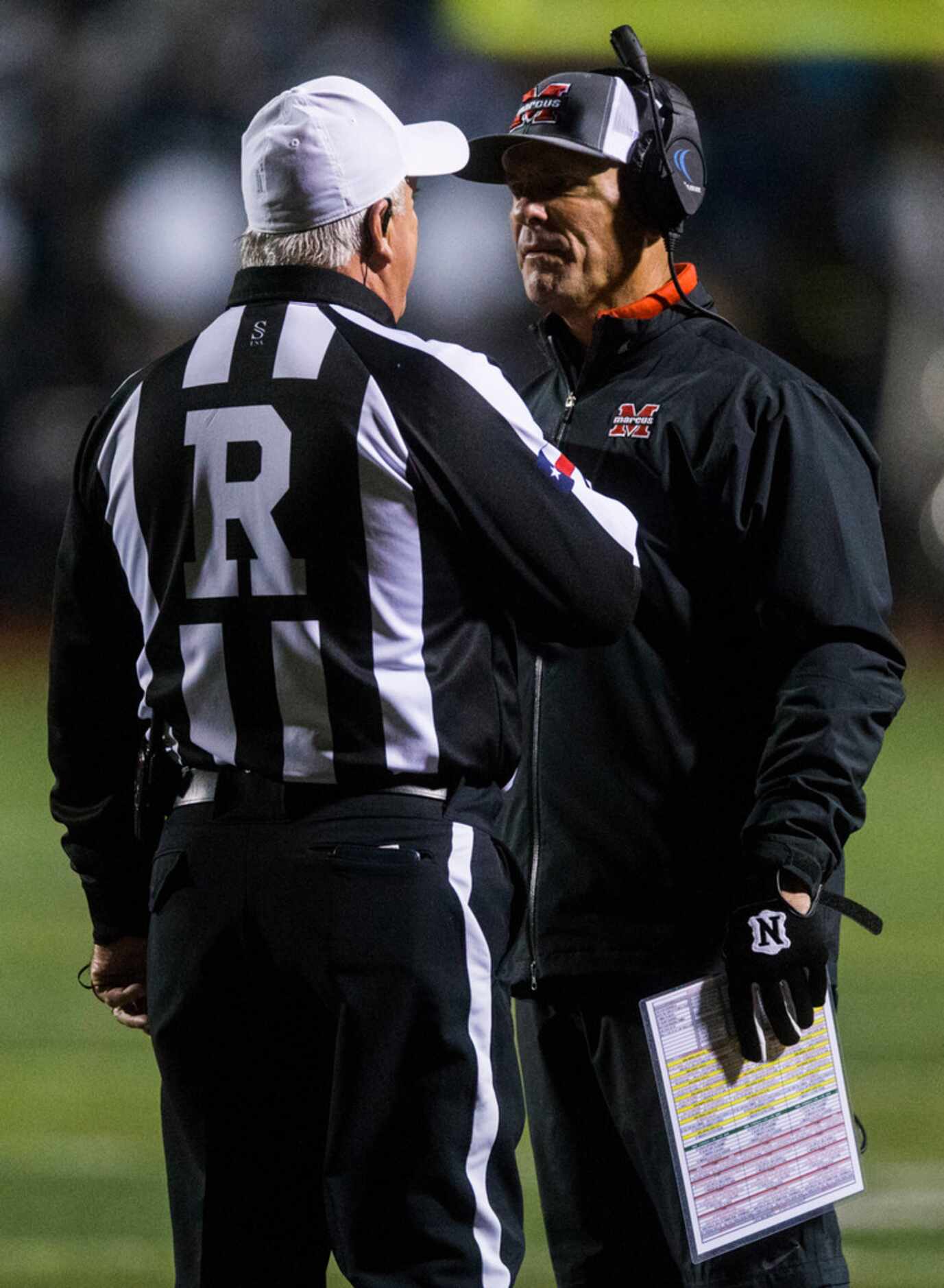 Flower Mound Marcus head coach Kevin Atkinson (right) talks to an official during the second...