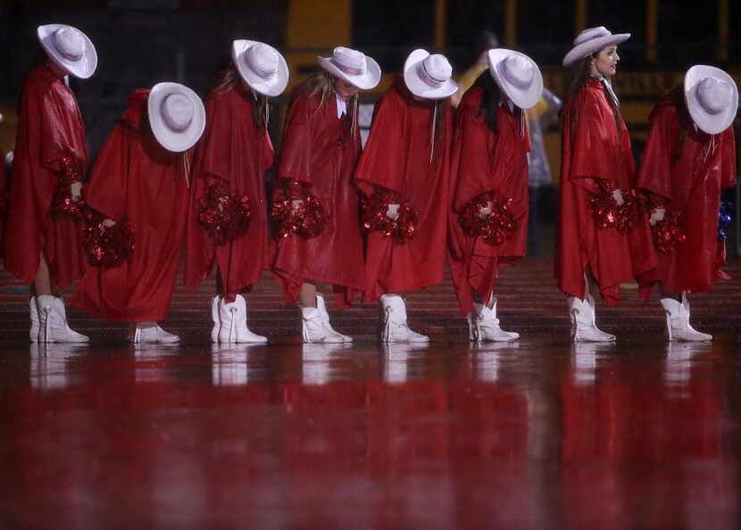 McKinney Boyd Bailadoras members try to get the rain off the top of their hats shortly...