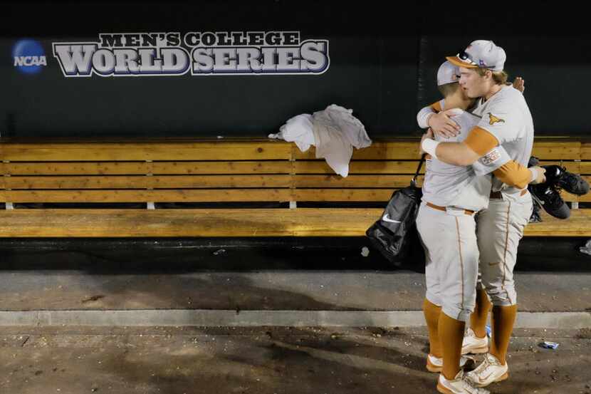 Texas' Mark Payton, left, and Kacy Clemens, right, hug in the dugout after Texas lost 4-3 to...