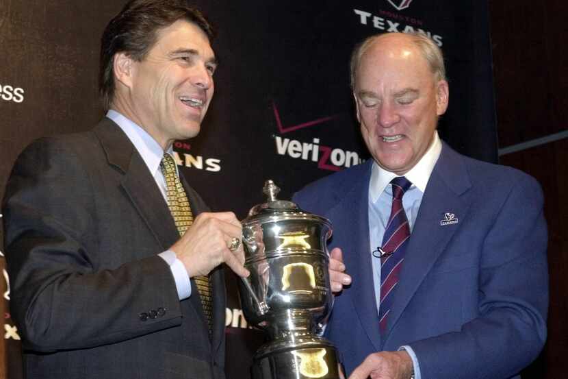Texas Gov. Rick Perry, left, presents the Governor's Cup to Houston Texans' owner Bob McNair...