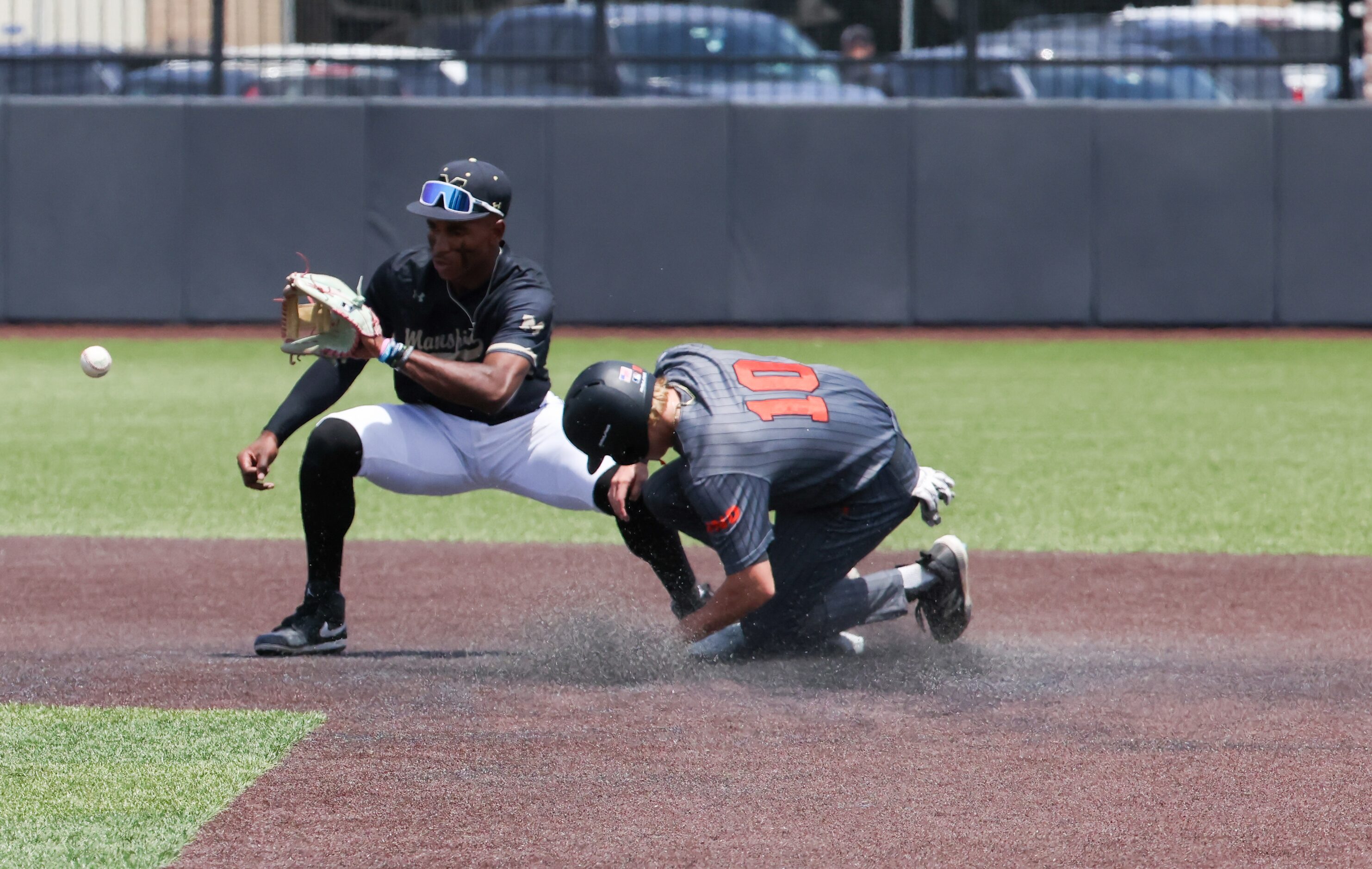 Rockwall junior Pearson Riebock (10) slides safely into second base just short of a catch by...