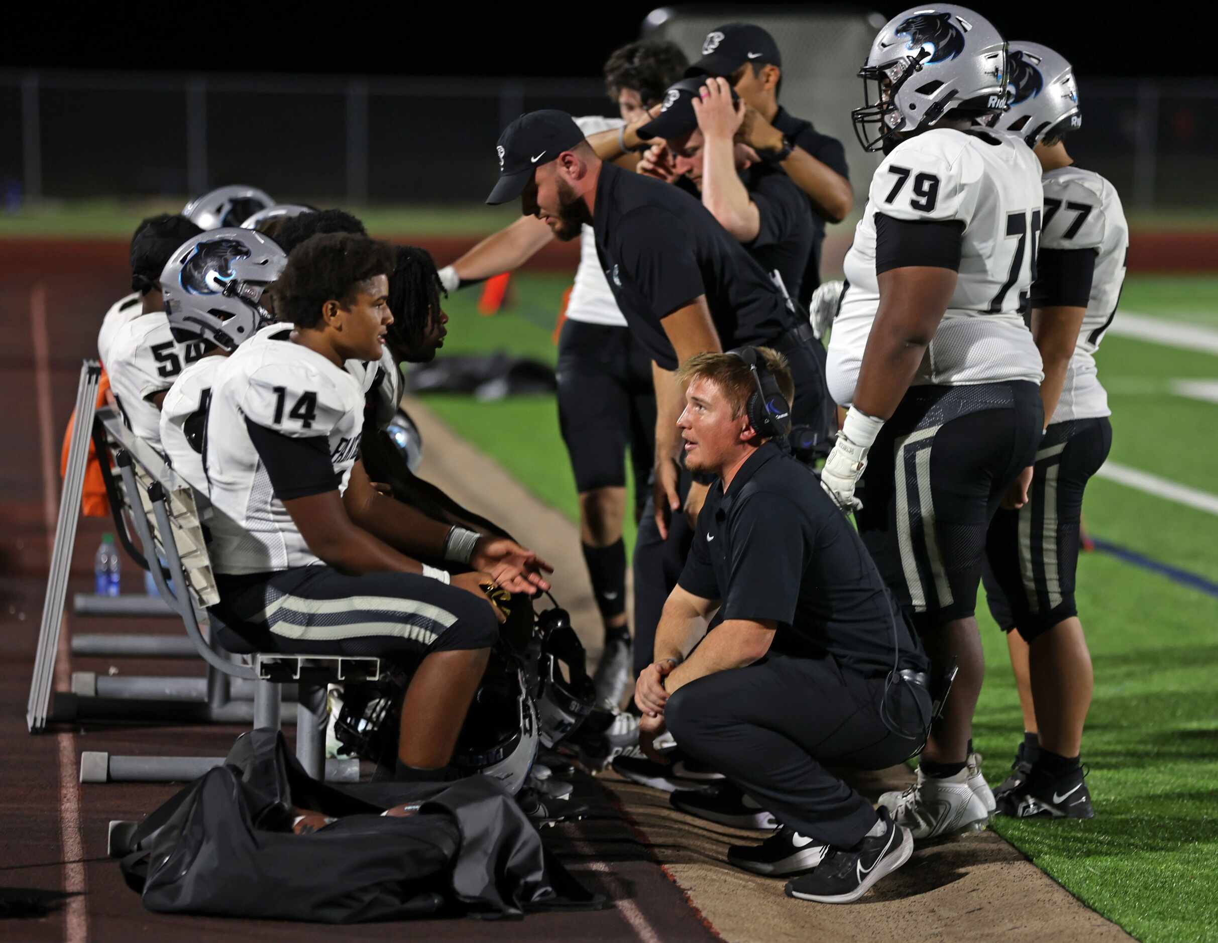 Frisco Panther Creek High players and coaches confer on the sideline during the first half...