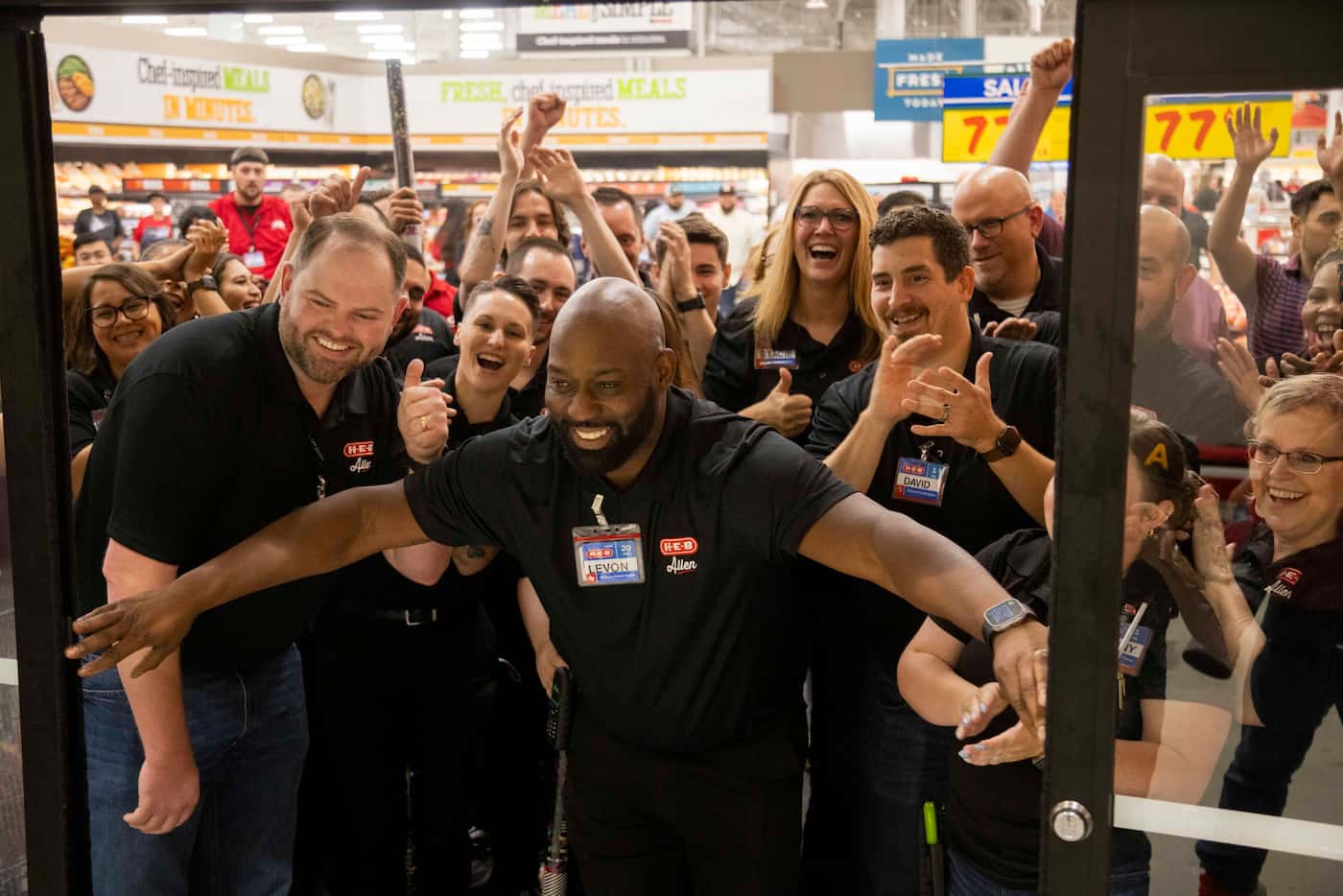Employees open the doors for the cameras before the grand opening of the H-E-B store in...