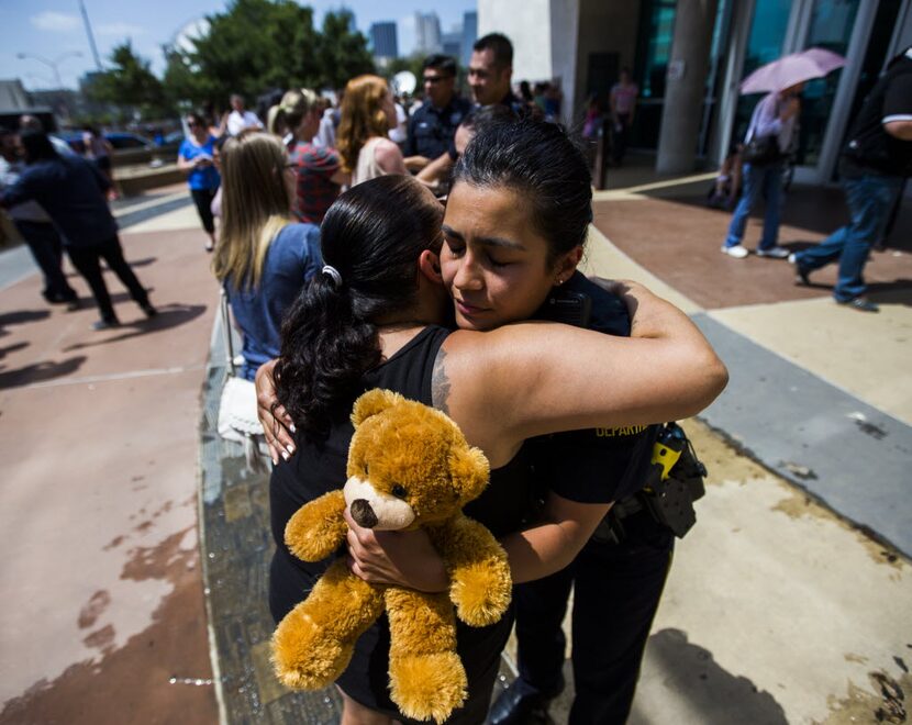 Dallas Police Officer Shawna Alvarez (right) gets a hug from a supporter on Sunday, July 10,...