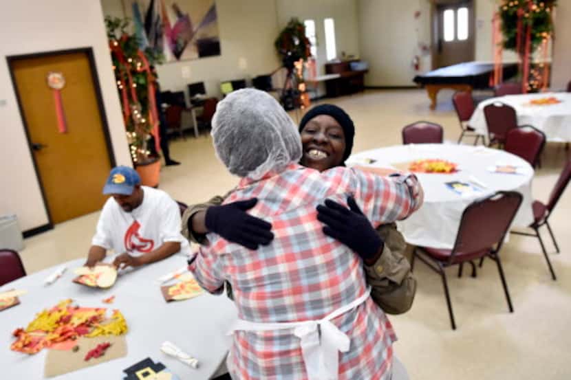 Natasha Perry es abrazada por una de las voluntarias durante un agasajo de Thanksgiving...