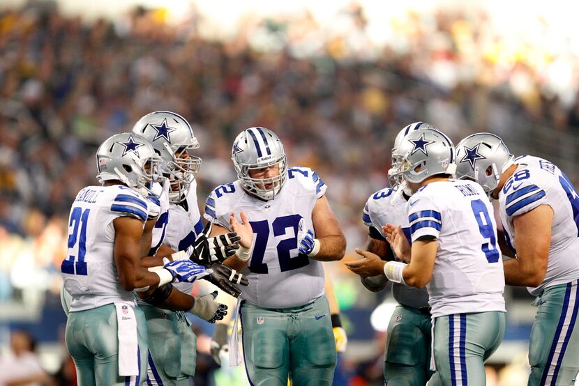 Dallas Cowboys center Travis Frederick (72) and the rest of the offense huddle around...