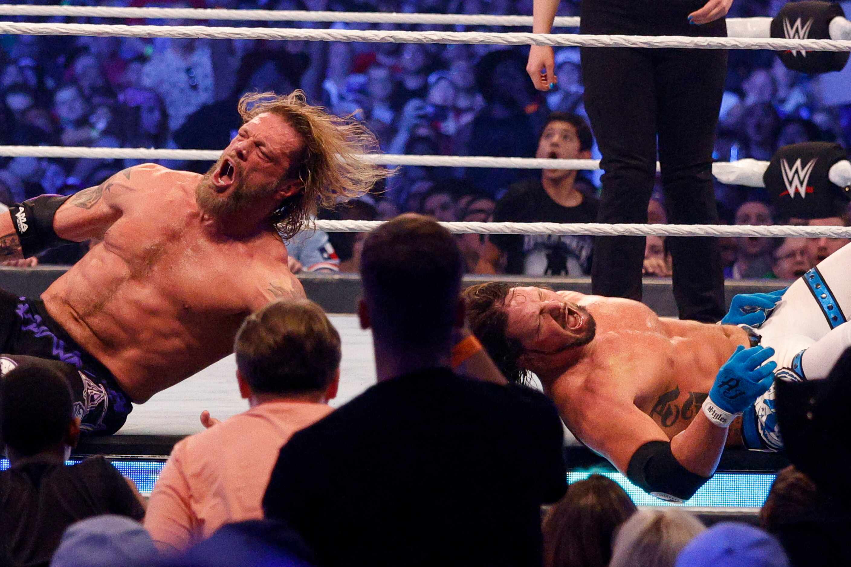 Edge (left) and AJ Styles react after a fall during a match at WrestleMania Sunday at AT&T...
