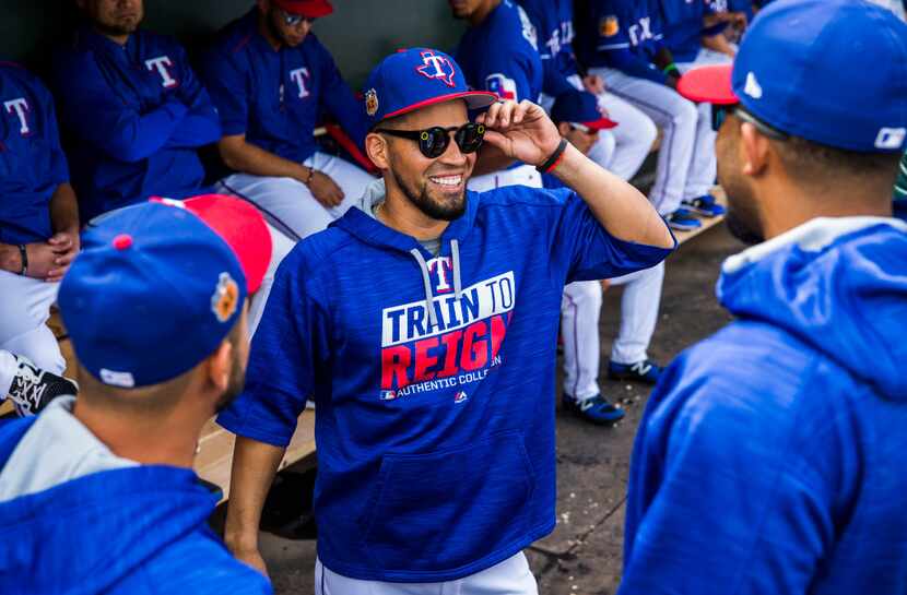 Texas Rangers catcher Robinson Chirinos (61, center) shows off his shades to starting...