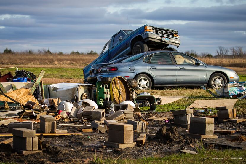Cars are strewn amid the rubble of a destroyed home in the 11800 block of County Road 670 on...